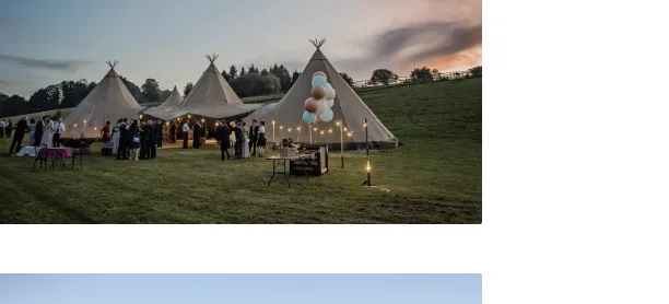 Illuminated tipis at dusk at Greenhill Farm